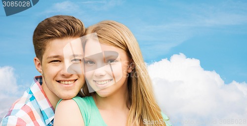 Image of smiling couple hugging over blue sky background