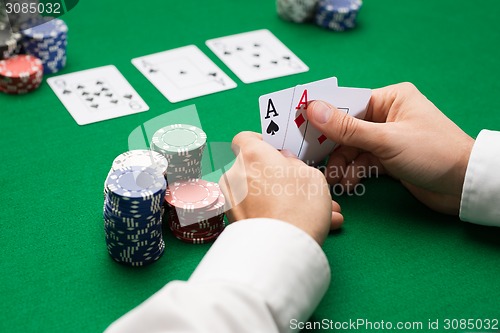 Image of poker player with cards and chips at casino