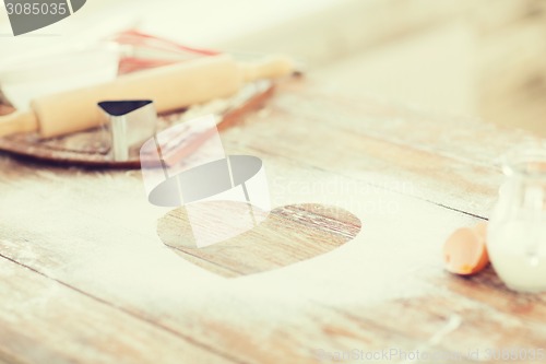 Image of close up of heart of flour on wooden table at home