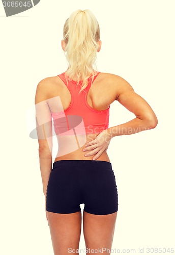 Image of sporty woman touching her back