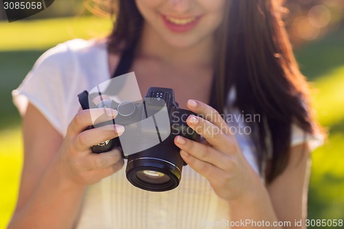 Image of close up of young girl with photo camera outdoors