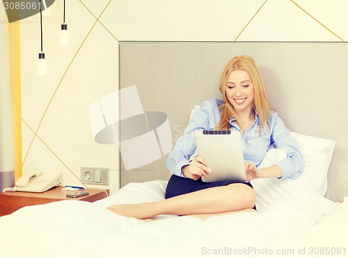 Image of happy businesswoman with tablet pc in hotel room