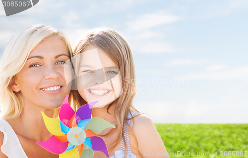 Image of happy mother and little girl with pinwheel toy