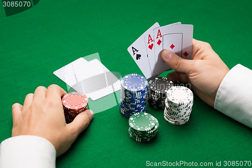 Image of poker player with cards and chips at casino