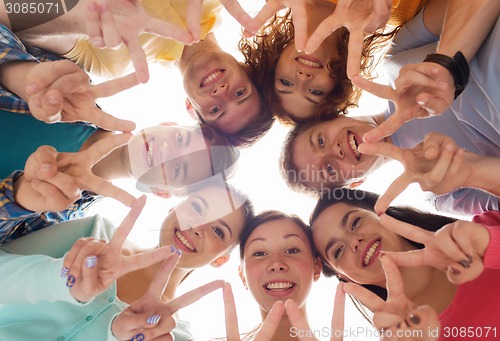 Image of group of smiling teenagers showing victory sign