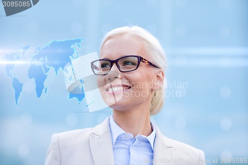 Image of young smiling businesswoman in eyeglasses outdoors