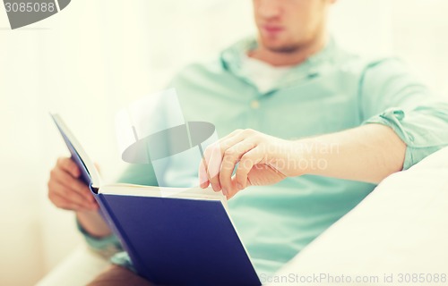 Image of close up of man reading book at home