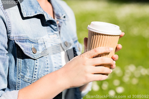 Image of close up of young girl with coffee cup outdoors