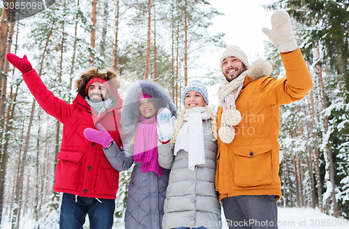 Image of group of friends waving hands in winter forest