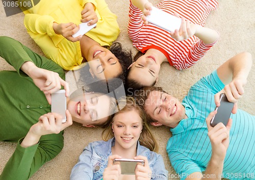 Image of group of smiling people lying down on floor