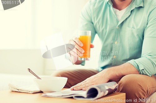 Image of close up of man with magazine drinking juice