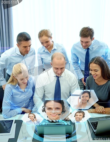 Image of smiling business people with laptop in office