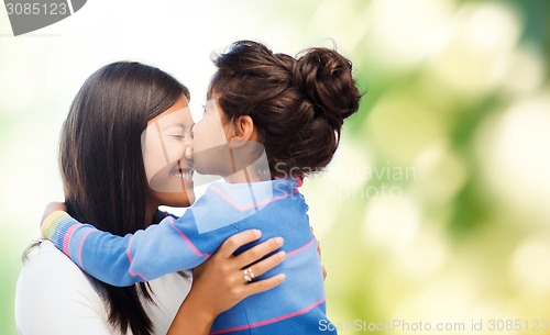 Image of happy little girl hugging and kissing her mother