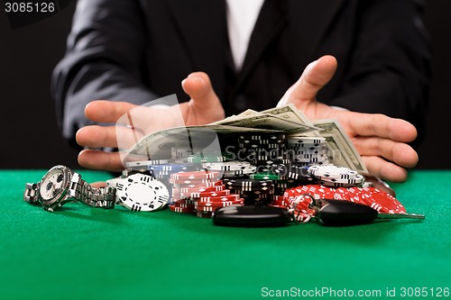 Image of poker player with chips and money at casino table