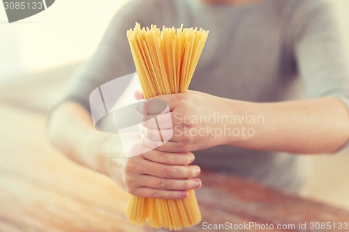 Image of close up of female hands holding spaghetti pasta