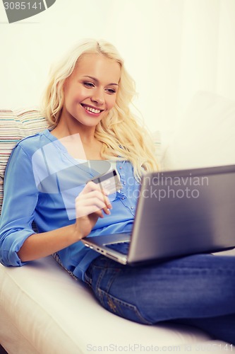 Image of smiling woman with laptop computer and credit card