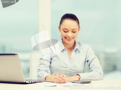 Image of businesswoman working with documents in office