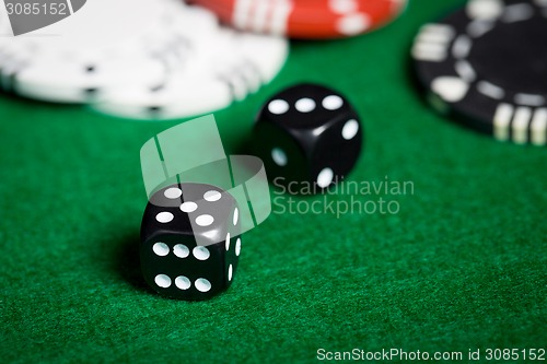 Image of close up of black dices on green casino table