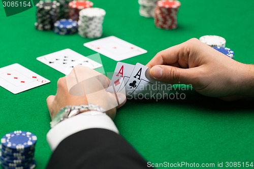 Image of poker player with cards and chips at casino