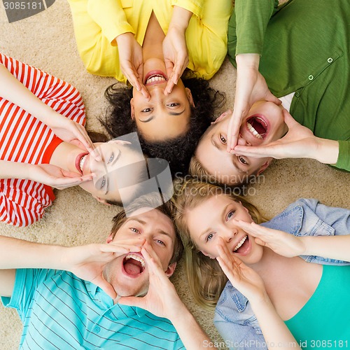 Image of smiling people lying down on floor and screaming