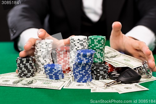 Image of poker player with chips and money at casino table