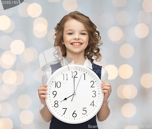 Image of smiling girl holding big clock