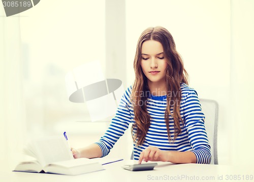 Image of student girl with book, calculator and notebook