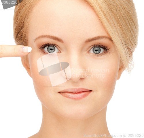 Image of beautiful woman pointing to eye