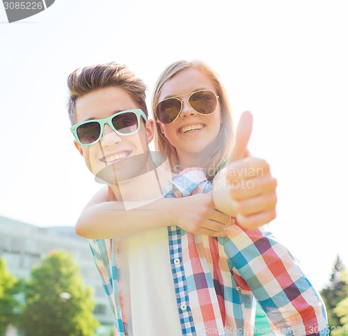 Image of smiling couple having fun and showing thumbs up