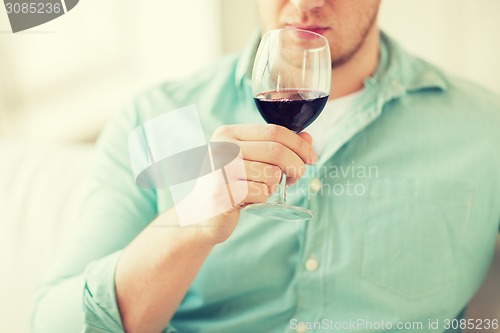 Image of close up of man drinking wine at home