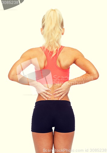 Image of sporty woman touching her back