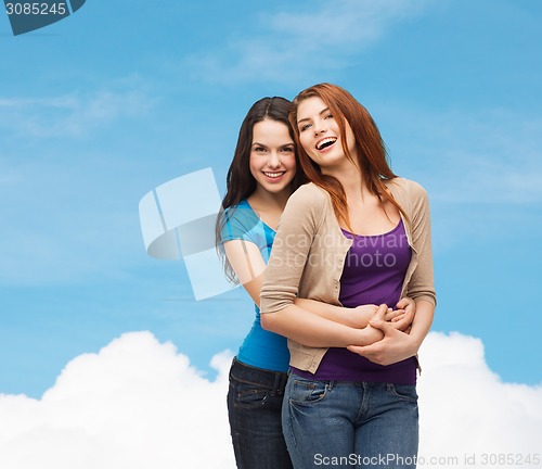 Image of smiling teenage girls hugging