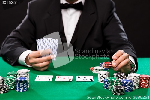 Image of poker player with cards and chips at casino