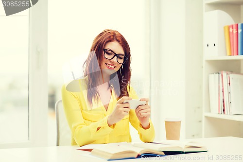 Image of smiling student girl with smartphone at school