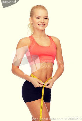 Image of smiling sporty woman with measuring tape