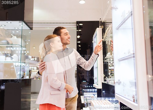 Image of couple looking to shopping window at jewelry store