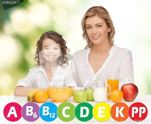 Image of happy mother and daughter eating breakfast