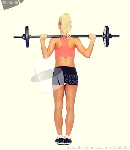 Image of sporty woman exercising with barbell from the back