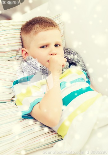 Image of ill boy with scarf lying in bed and coughing