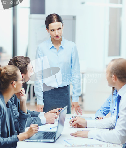 Image of strict female boss talking to business team