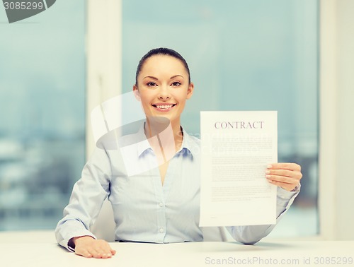 Image of happy businesswoman holding contract in office