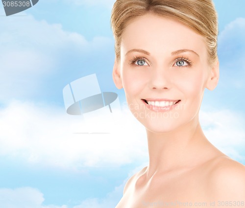 Image of close up of smiling woman over blue sky background