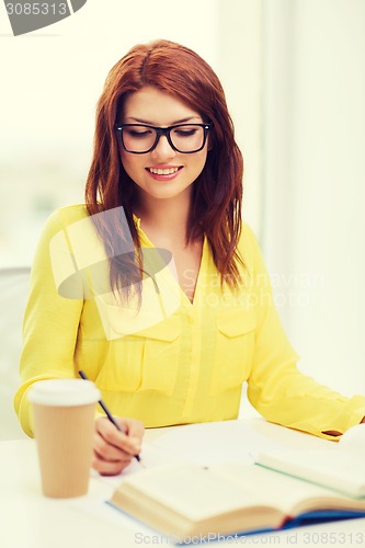 Image of smiling student girl reading books in library