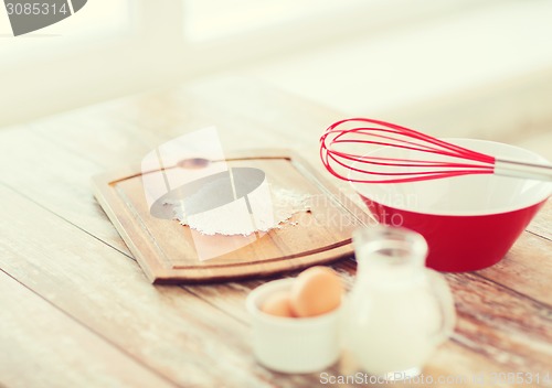 Image of jugful of milk, eggs in a bowl and flour