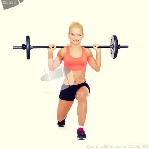 Image of smiling sporty woman exercising with barbell