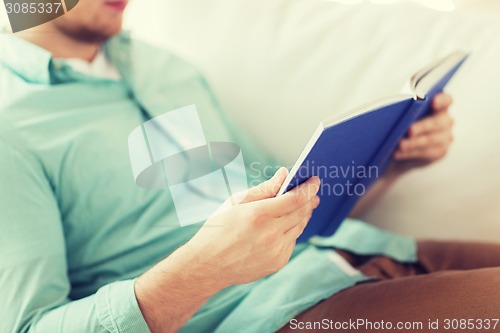 Image of close up of man reading book at home