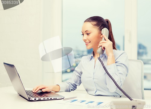 Image of businesswoman with phone, laptop and files