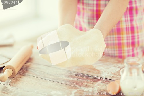 Image of close up of female hands holding bread dough