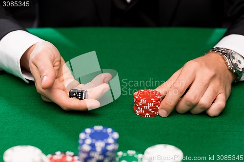 Image of poker player with dice and chips at casino