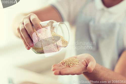 Image of close up of male emptying jar with quinoa